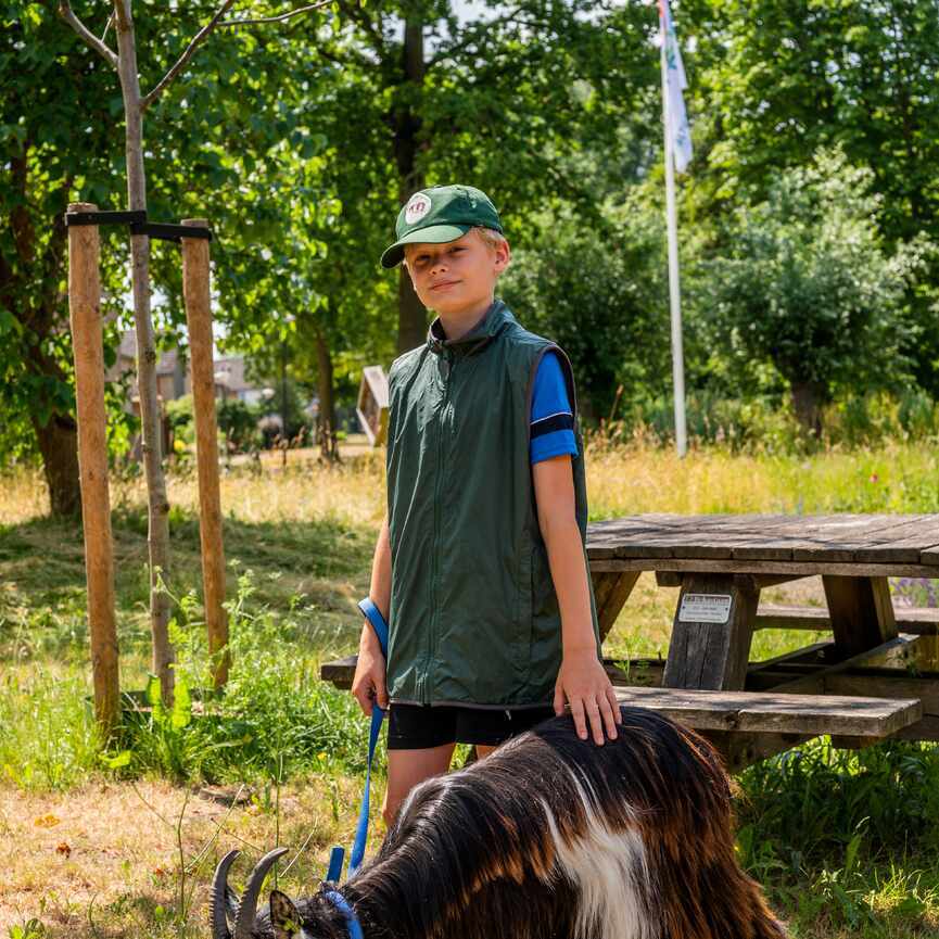 Jongen met geit aan een lijn